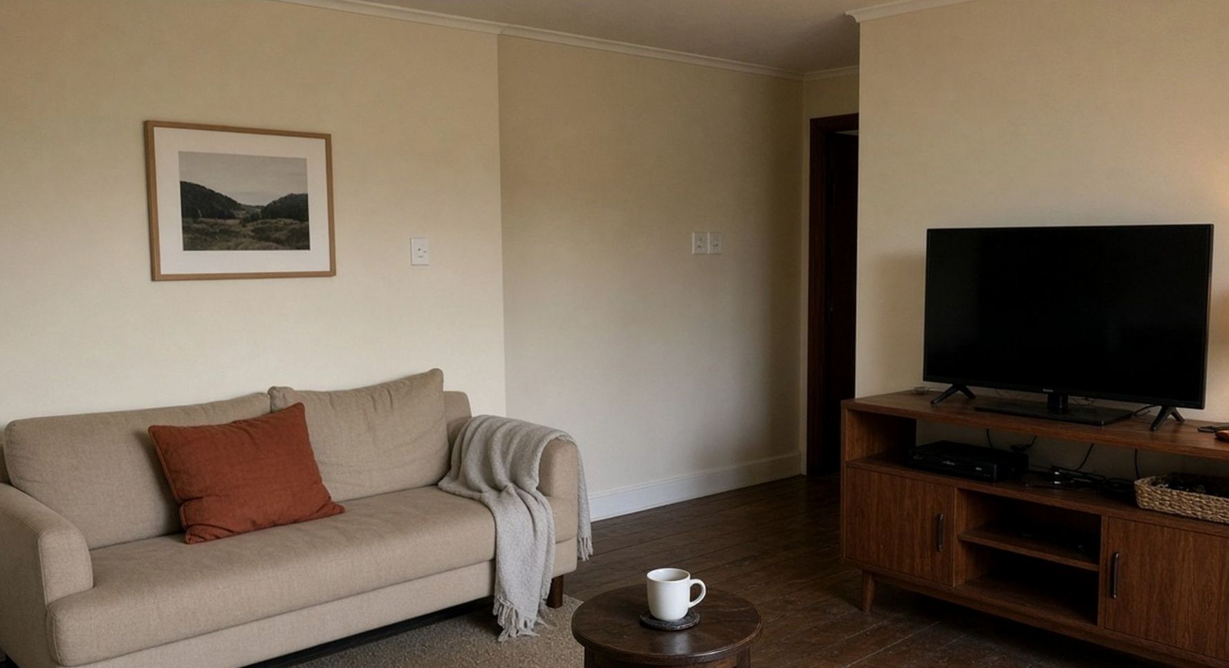 Small sitting room with a low sofa and a blank television